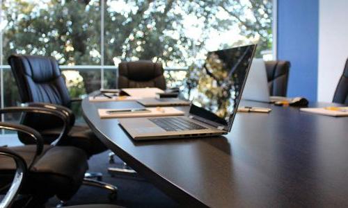 An empty meeting room with an open laptop